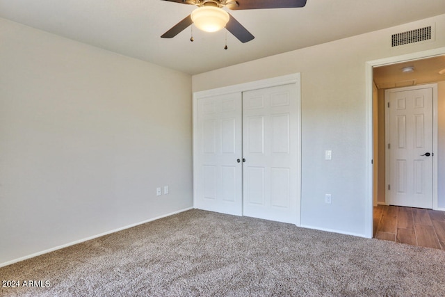 unfurnished bedroom featuring a closet, dark carpet, and ceiling fan