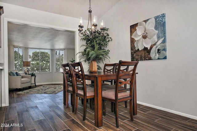 dining room featuring an inviting chandelier, vaulted ceiling, and dark hardwood / wood-style flooring