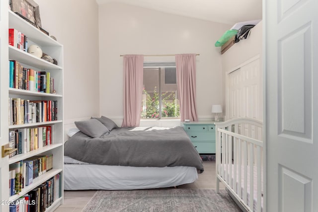 bedroom featuring wood finished floors and lofted ceiling