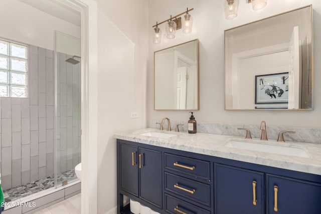full bath with a shower stall, double vanity, and toilet