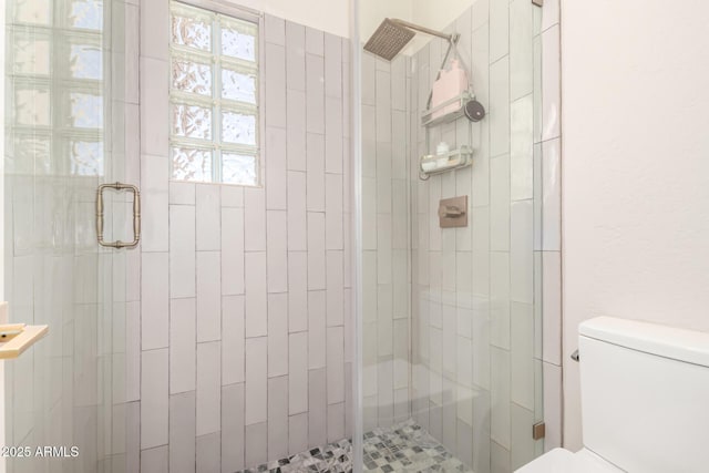 full bath with a stall shower and toilet