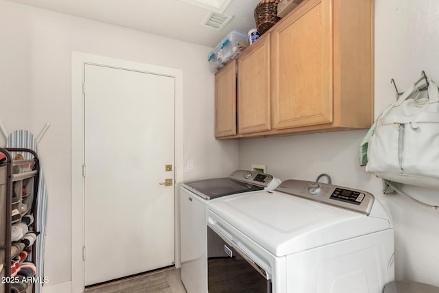 laundry area featuring washer and dryer, cabinet space, and light wood-style flooring