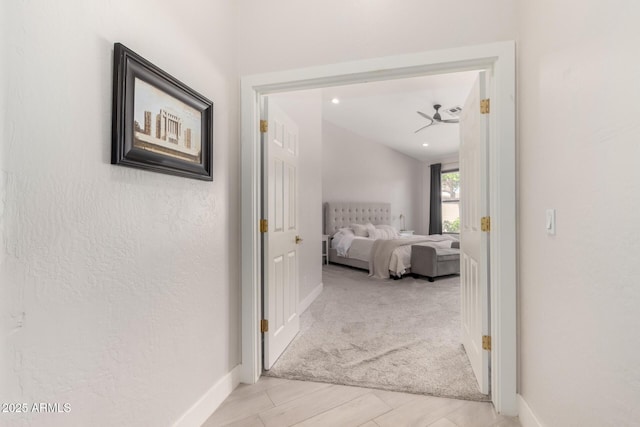 hall with baseboards and carpet