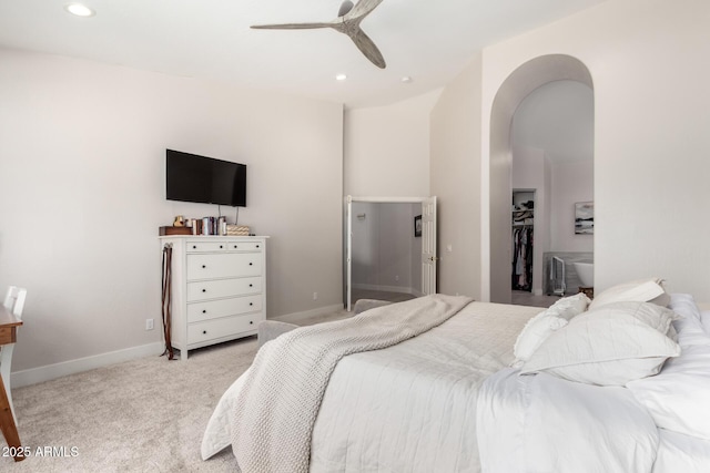 carpeted bedroom with arched walkways, recessed lighting, ceiling fan, a spacious closet, and baseboards