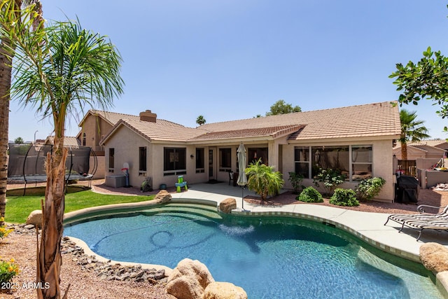 view of pool featuring a trampoline, a patio, and fence