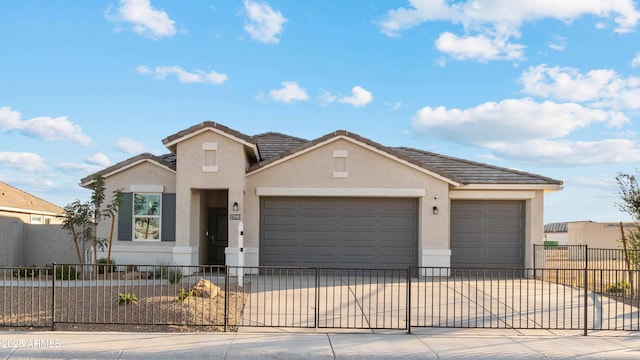 view of front of home featuring an attached garage, a fenced front yard, driveway, and stucco siding