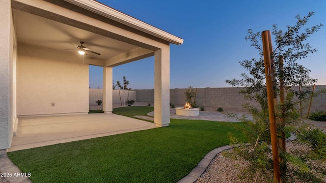 view of yard featuring a patio area, ceiling fan, an outdoor fire pit, and a fenced backyard