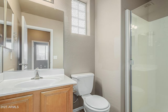 full bath with vanity, a textured wall, toilet, and a shower stall