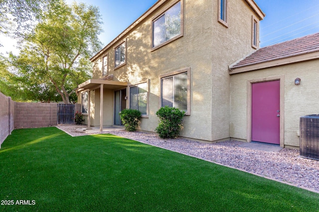 rear view of house featuring a fenced backyard, a lawn, stucco siding, and cooling unit