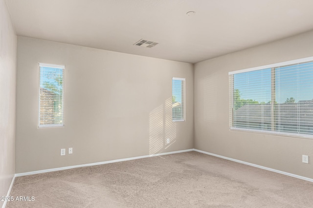 carpeted empty room with baseboards and visible vents
