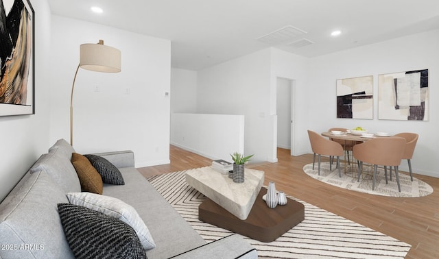 living room featuring recessed lighting, wood finished floors, and baseboards