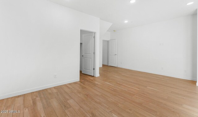 empty room featuring recessed lighting, baseboards, and light wood finished floors