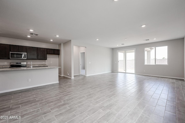2514 E Music Mountain Ave, Apache Junction, AZ 85119 - unfurnished living room with recessed lighting, baseboards, a sink, and light wood-type flooring