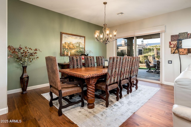 dining area with a notable chandelier and hardwood / wood-style flooring