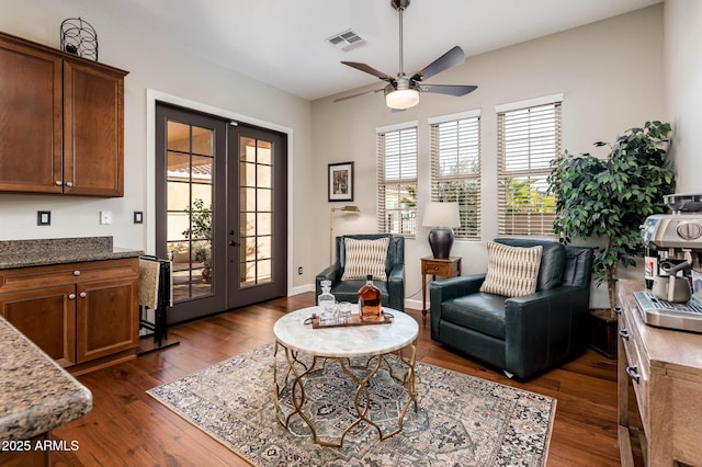 sitting room with dark wood-type flooring, ceiling fan, and french doors