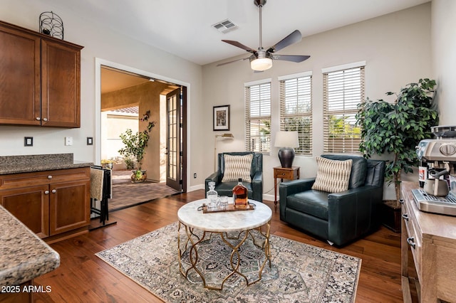 sitting room with dark wood-type flooring and ceiling fan