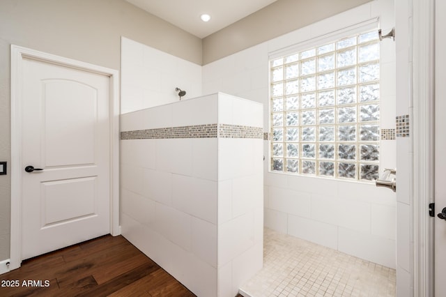 bathroom featuring hardwood / wood-style flooring and tiled shower