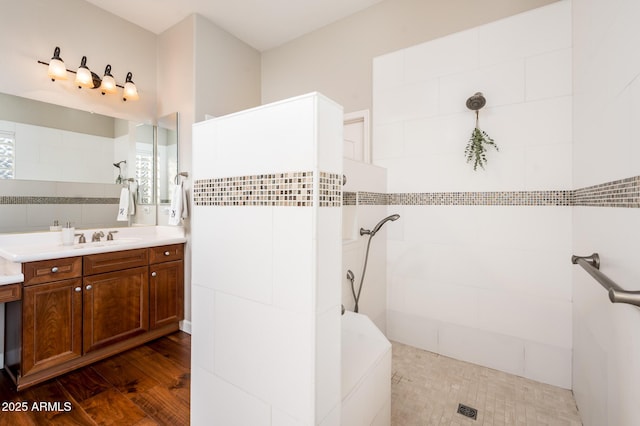 bathroom with vanity, wood-type flooring, and tiled shower