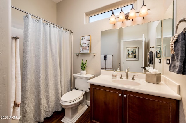 bathroom with vanity, curtained shower, and toilet