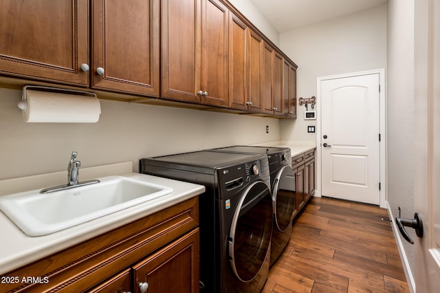 clothes washing area featuring cabinets, washing machine and dryer, sink, and dark wood-type flooring