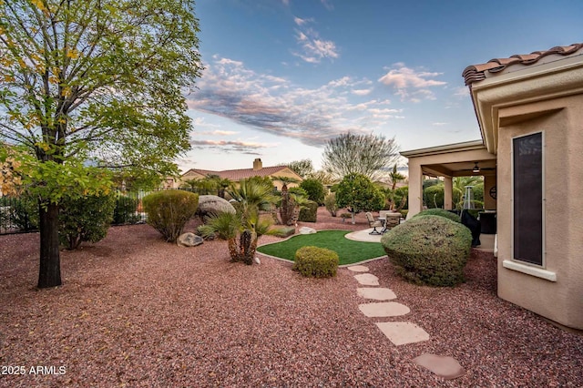 yard at dusk featuring a patio area