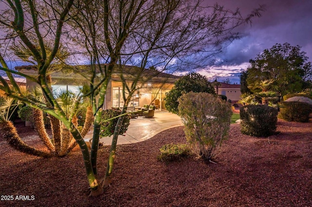 yard at dusk with a patio area