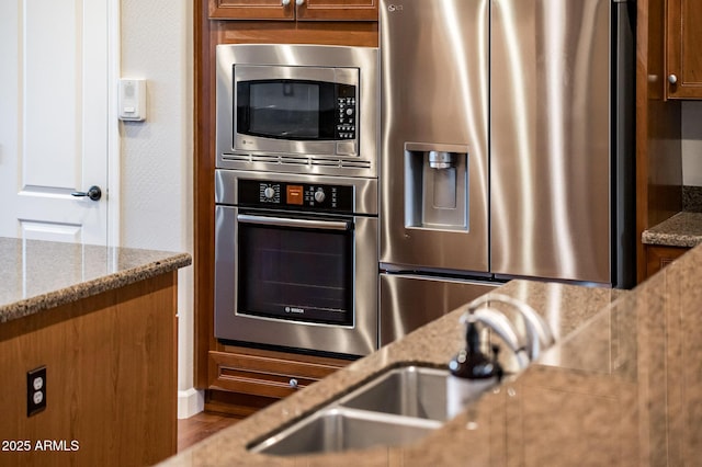 kitchen with light stone countertops and appliances with stainless steel finishes