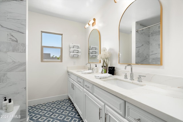 bathroom with a sink, baseboards, walk in shower, and double vanity