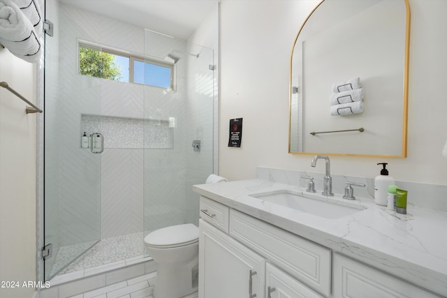 bathroom featuring toilet, a stall shower, and vanity