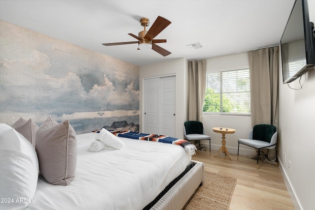 bedroom with ceiling fan, wood finished floors, visible vents, and baseboards