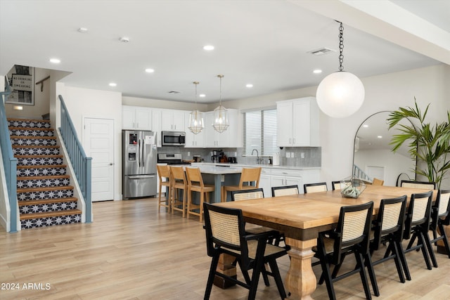 dining space with recessed lighting, stairway, and light wood-style flooring