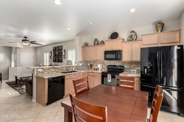 kitchen with kitchen peninsula, sink, black appliances, and light brown cabinets