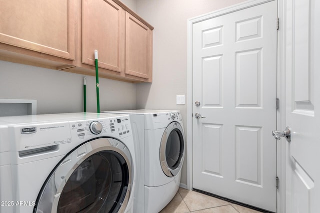 laundry room with cabinets, washer and dryer, and light tile patterned flooring