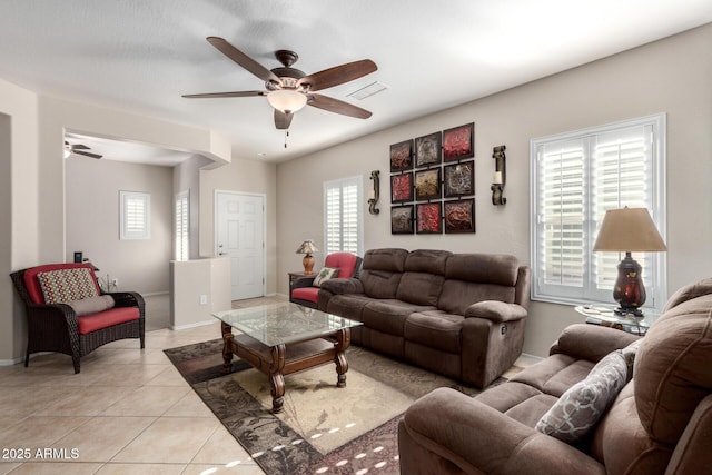 tiled living room with a wealth of natural light and ceiling fan