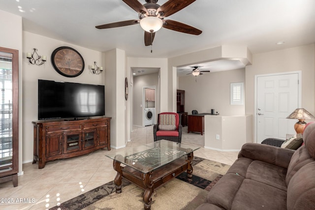 living room with ceiling fan, light tile patterned floors, and washer / dryer