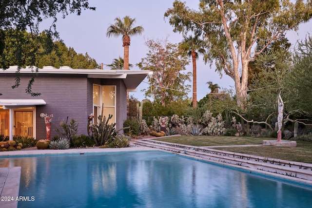 view of swimming pool with a lawn