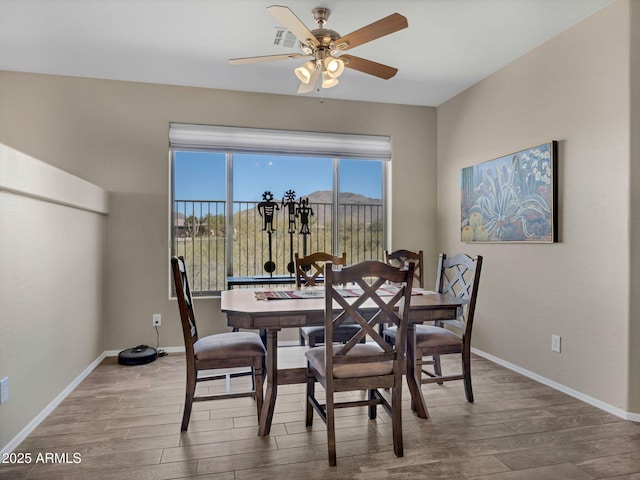 dining space with ceiling fan, baseboards, and wood finished floors