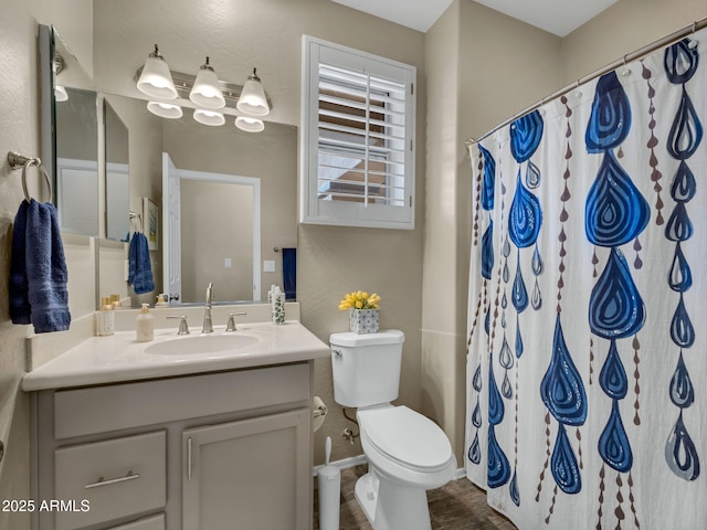 full bath featuring toilet, baseboards, a shower with shower curtain, and vanity