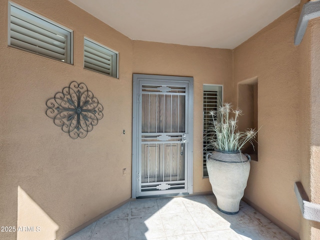 property entrance with stucco siding