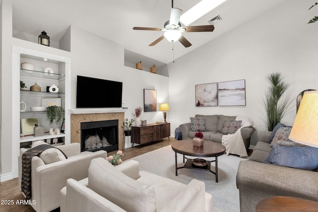 living room featuring high vaulted ceiling, ceiling fan, and built in shelves