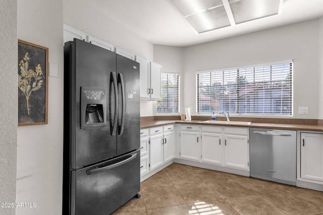 kitchen with stainless steel dishwasher, black fridge with ice dispenser, sink, and white cabinets