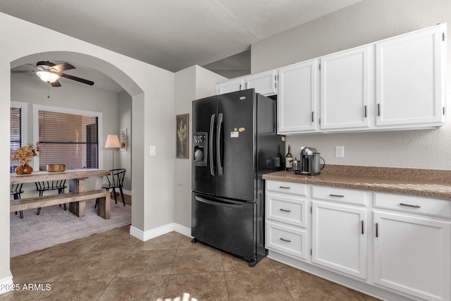 kitchen with white cabinetry, ceiling fan, black refrigerator with ice dispenser, and light tile patterned floors