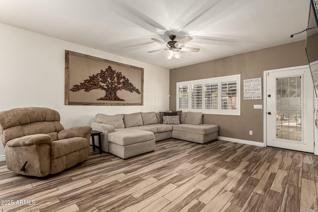 living room featuring wood finished floors, baseboards, and ceiling fan