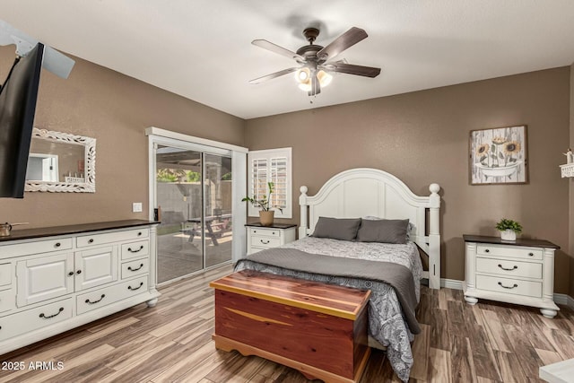 bedroom with wood finished floors, access to exterior, a ceiling fan, and baseboards