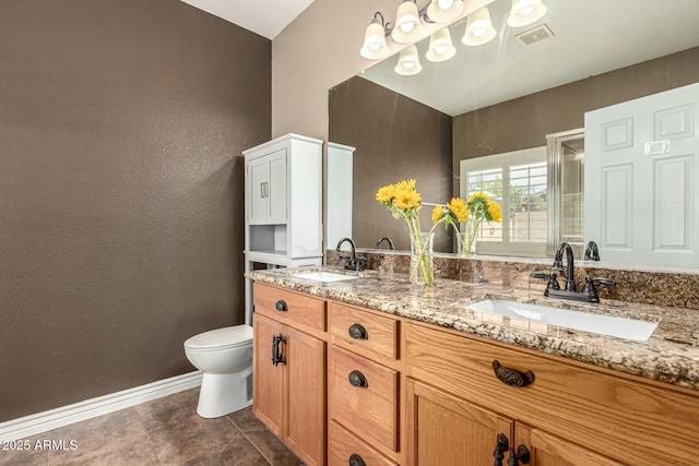 bathroom with toilet, a textured wall, a sink, and a stall shower