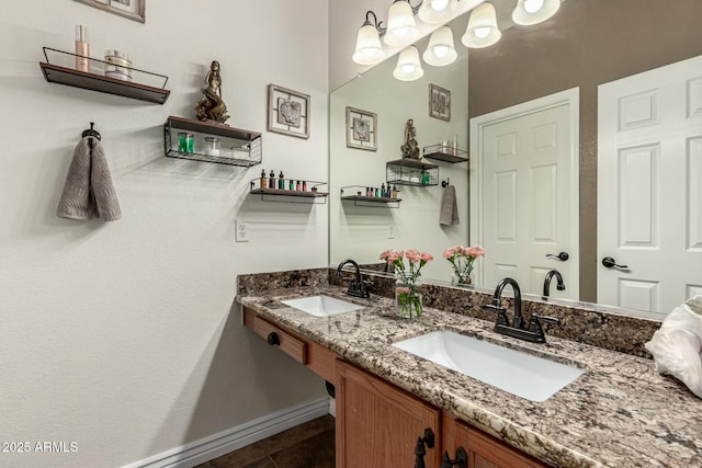 bathroom featuring double vanity, tile patterned flooring, baseboards, and a sink