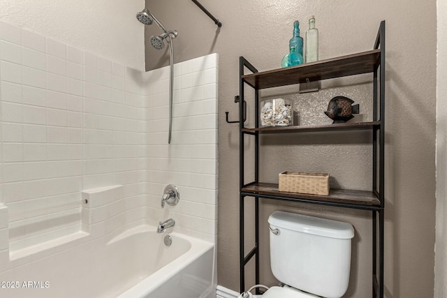 bathroom with toilet, a textured wall, and shower / washtub combination