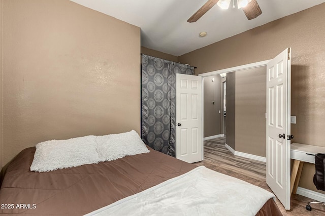 bedroom featuring wood finished floors, a ceiling fan, and baseboards