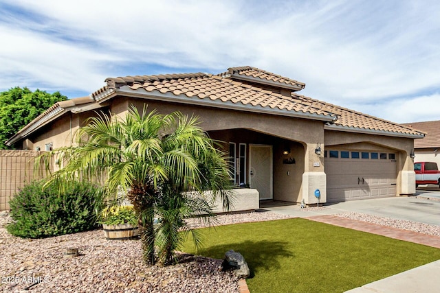 mediterranean / spanish-style home featuring stucco siding, fence, concrete driveway, and a garage