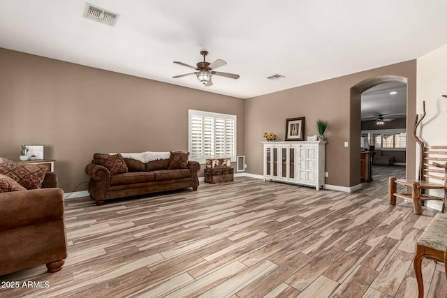 living room featuring wood finished floors, a ceiling fan, and visible vents